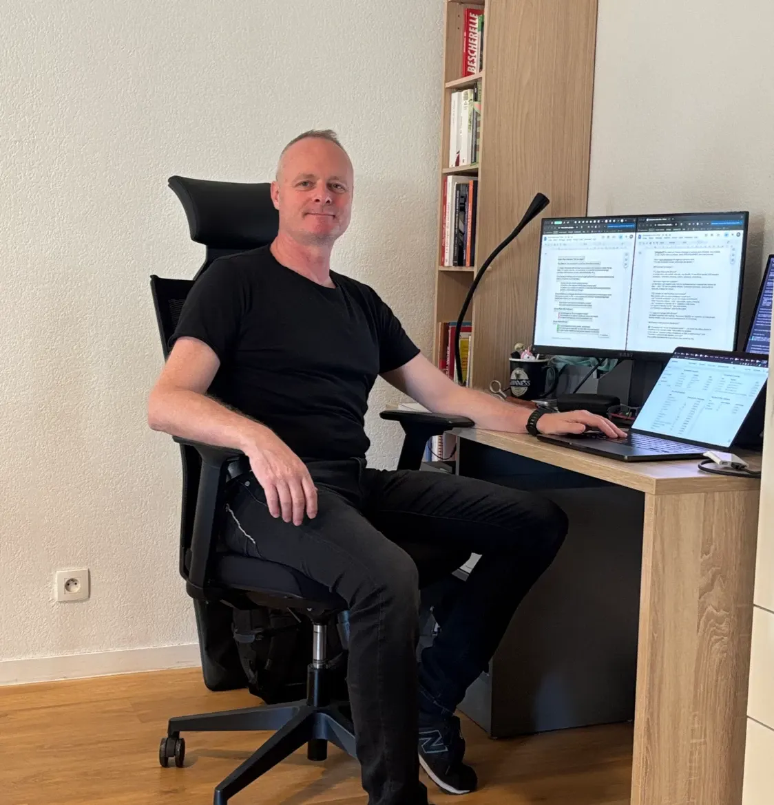 Thomas assis à son bureau, devant ses écrans de travail